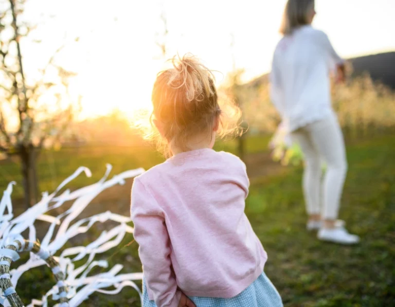 Niña jugando en jardin con su madre